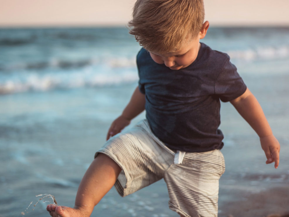 Portrait of a young boy playing in the ocean at Fort Fisher captured by Wilmington, NC family photographer Salty Star Photography