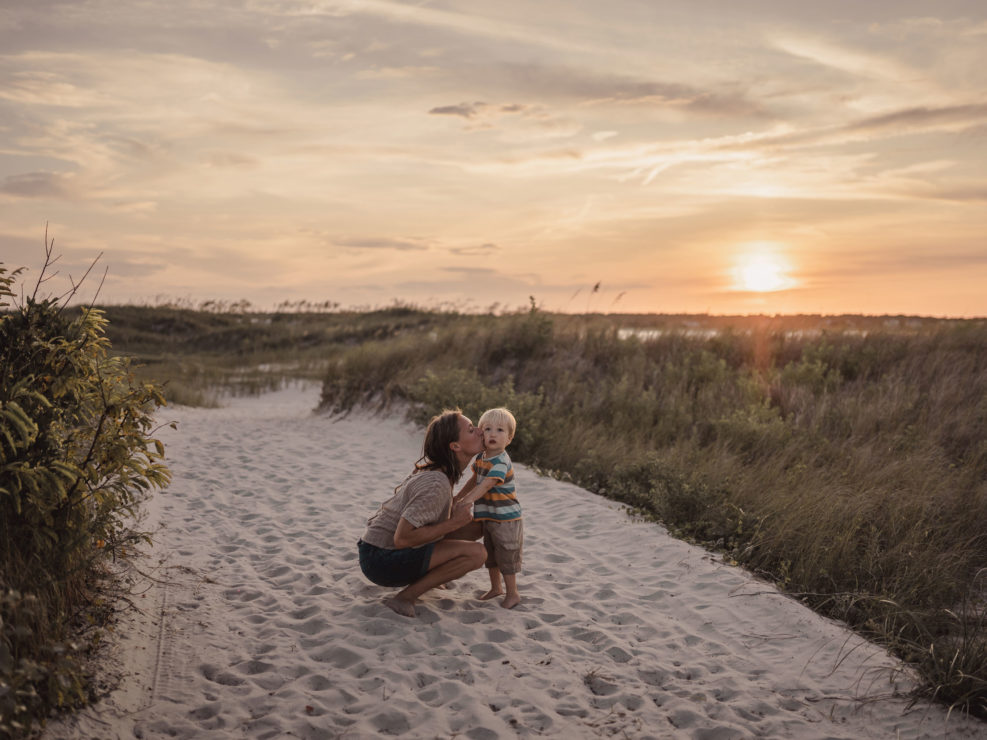 Portrait of a mother and son standing in the sand at Wrightsville Beach captured by Wilmington, NC family photographer Salty Star Photography