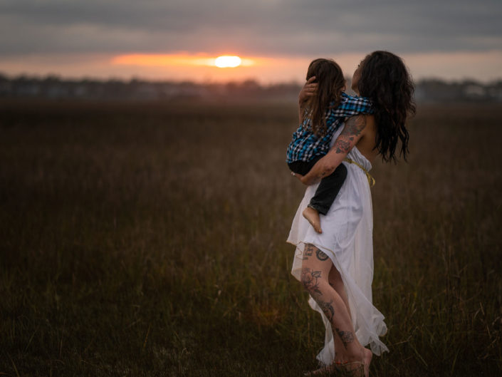 Portrait of a mother holding her young son by the marsh at Wrightsville Beach captured by Wilmington, NC family photographer Salty Star Photography