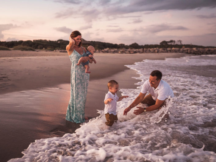 Portrait of a family playing in the waves at Fort Fisher, NC captured by Salty Star Photography