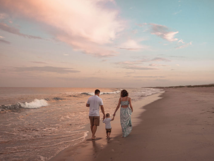 A family walking along the beach at sunset in Fort Fisher, NC captured by Salty Star Photography