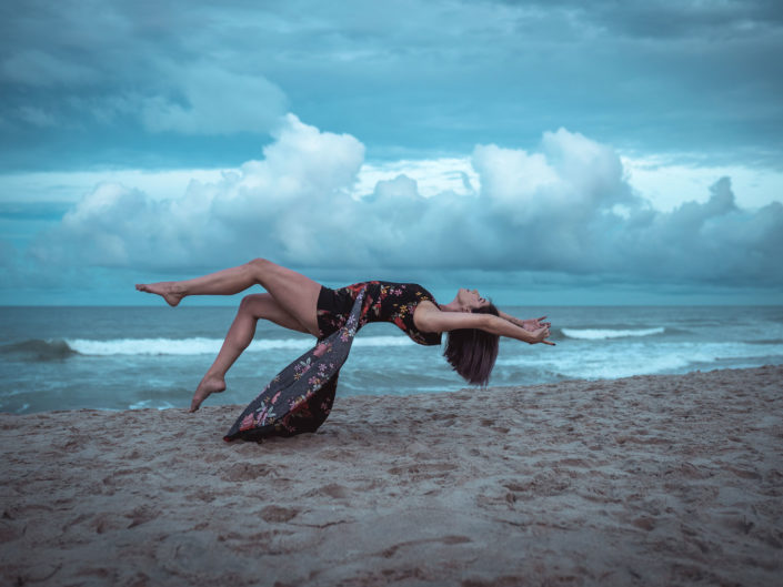 Levitation portrait of a dancer in front of storm clouds at Carolina Beach, NC captured by Salty Star Photography